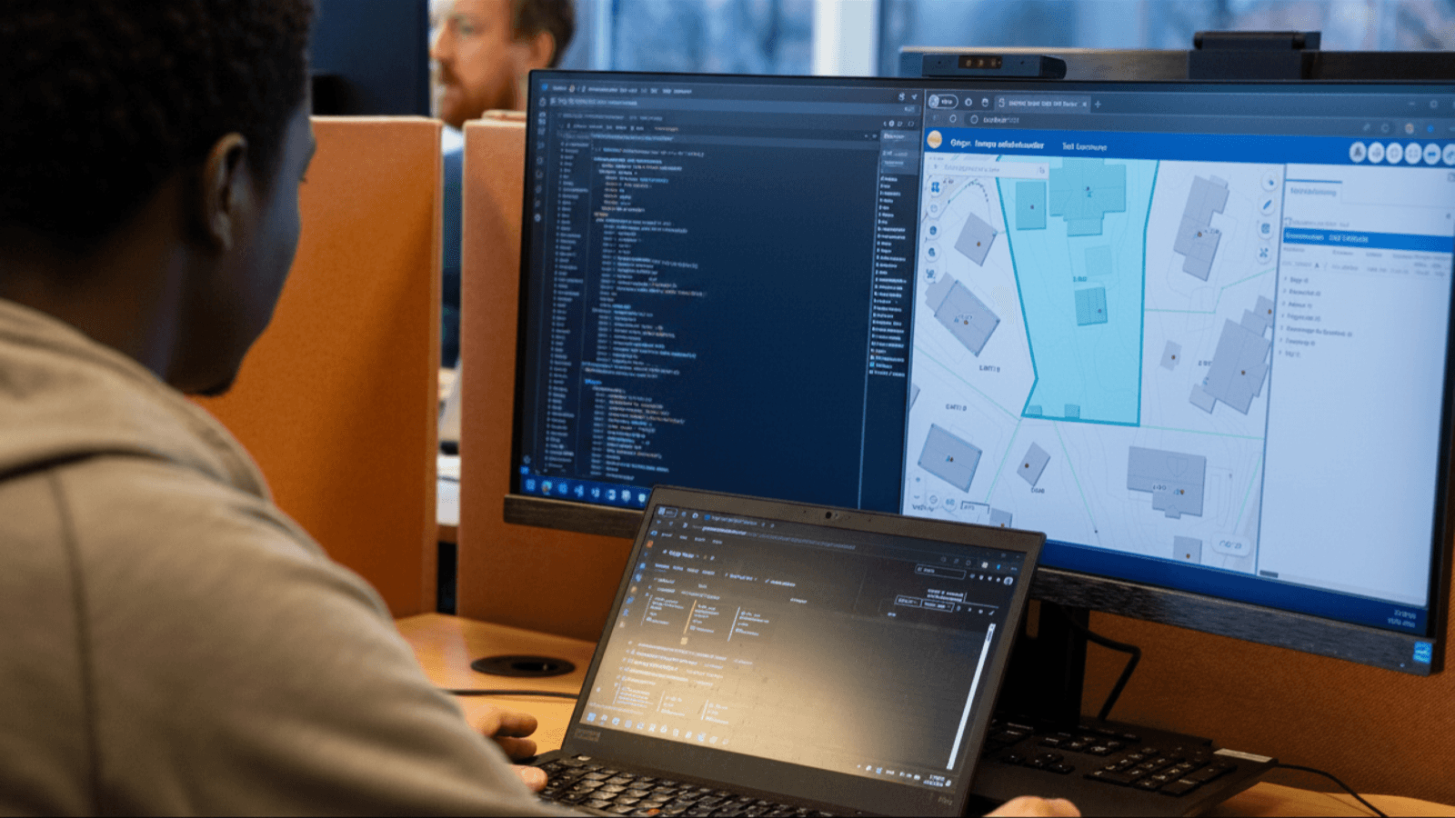 Developer workstation showing GIS software and code